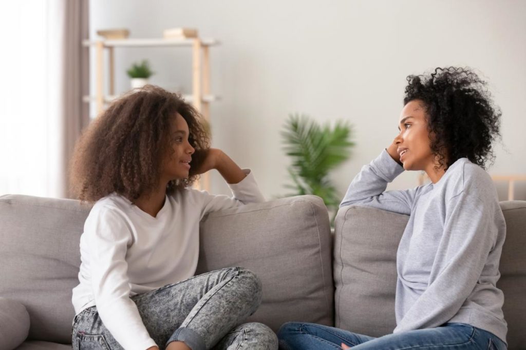 two women sitting on couch discussing the 5 benefits of behavioral therapy