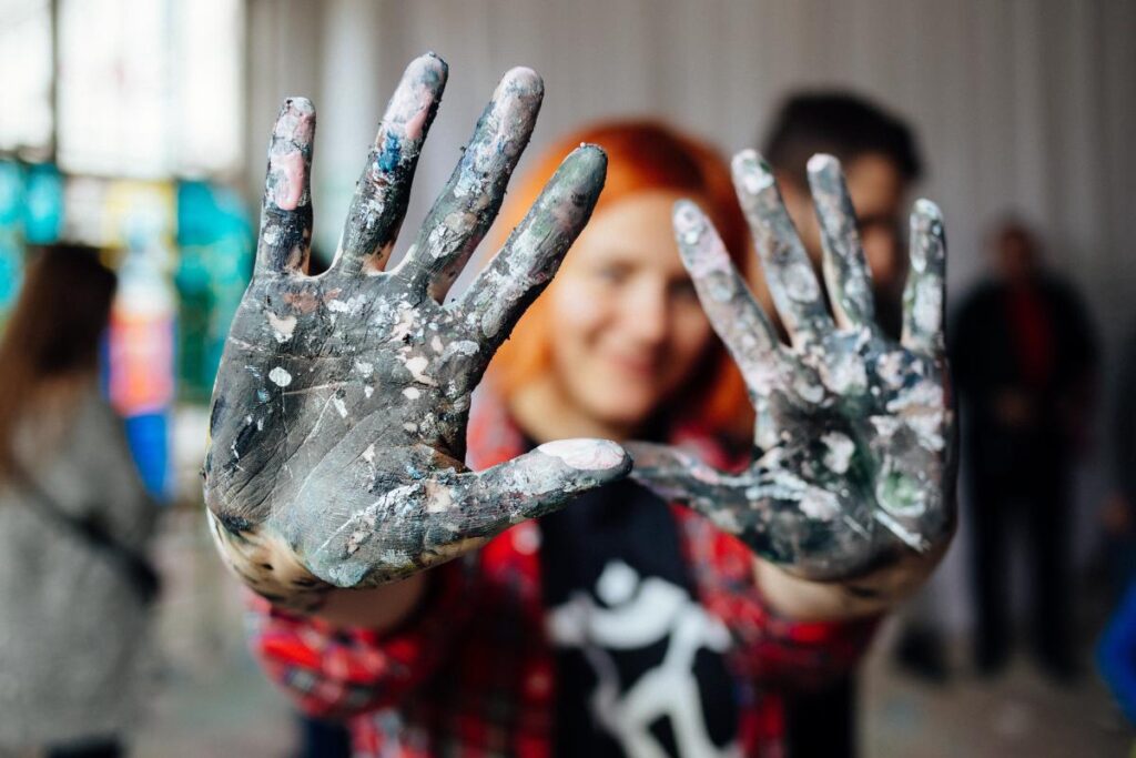 teenage girl showing palms covered in paint after engaging in activities to help fight depression